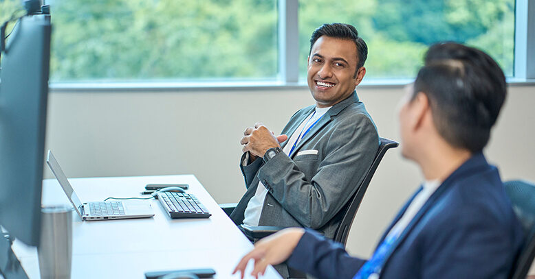 A man smiling at a colleague in office