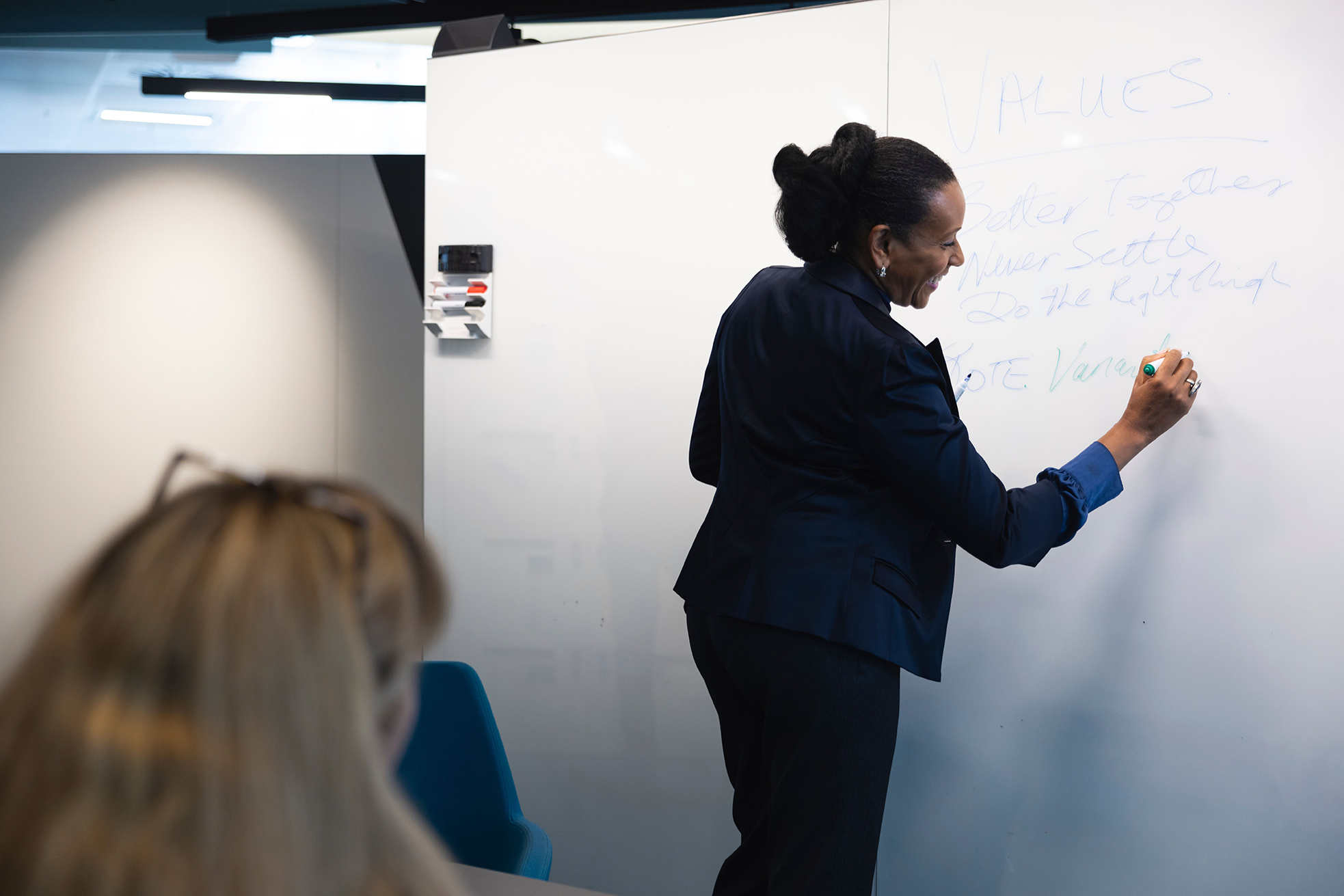 A woman writing on the white board