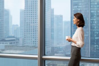 A smiling woman looking outside of a window