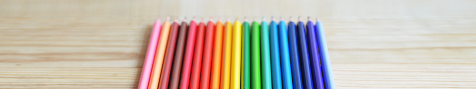 a set of color pencils on a wooden table