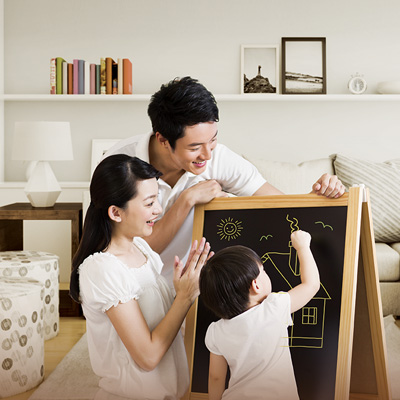 爸媽鼓勵著他們的孩子在黑板上畫出房屋