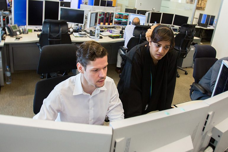 Employees looking at computer screen