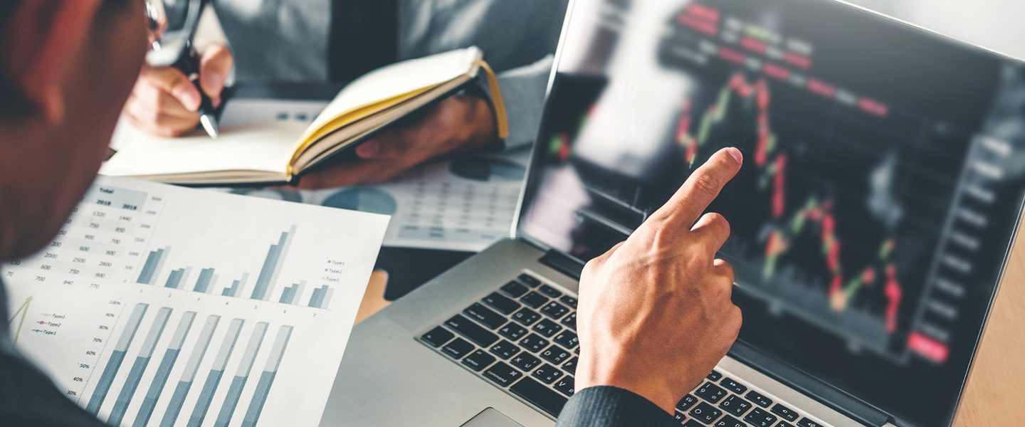 man pointing at graph on laptop