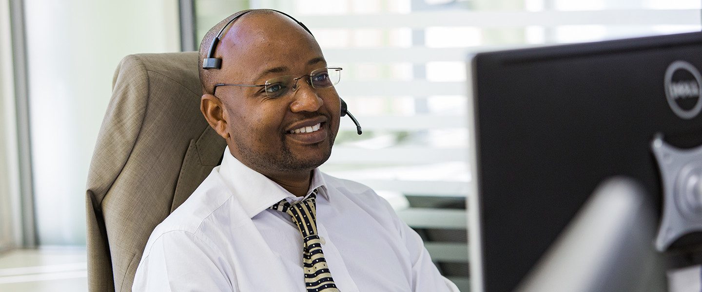man sat at computer using headset