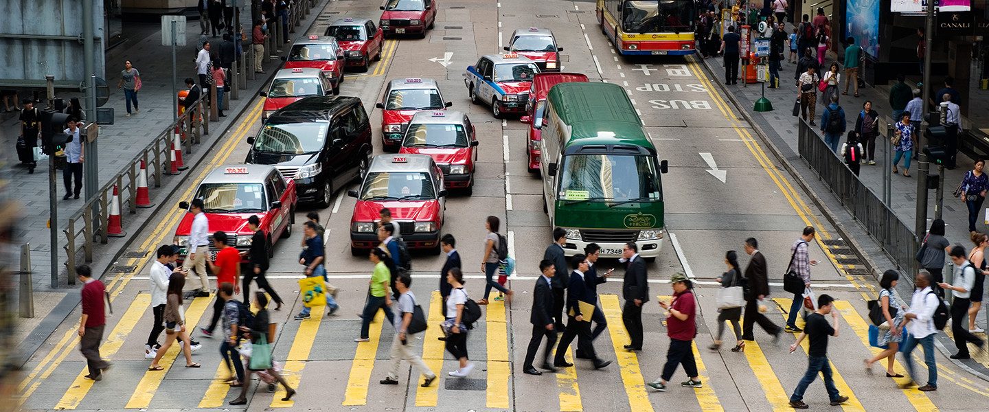 people using zebra crossing on busy street