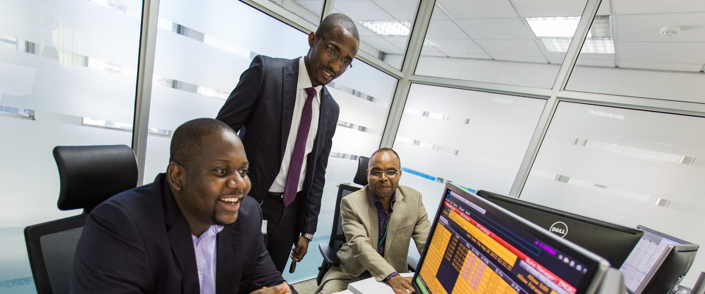 Three men looking at the computer screen looking at their digital assets