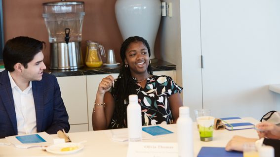 two students talking at a table