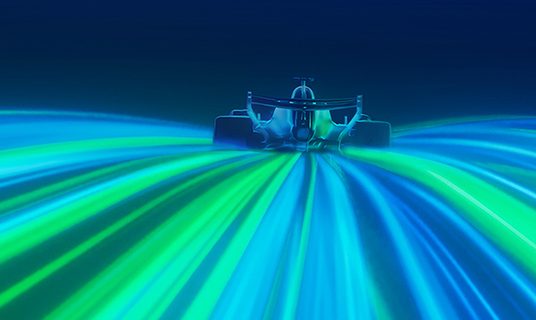 A car rides streaks of blue and green light.