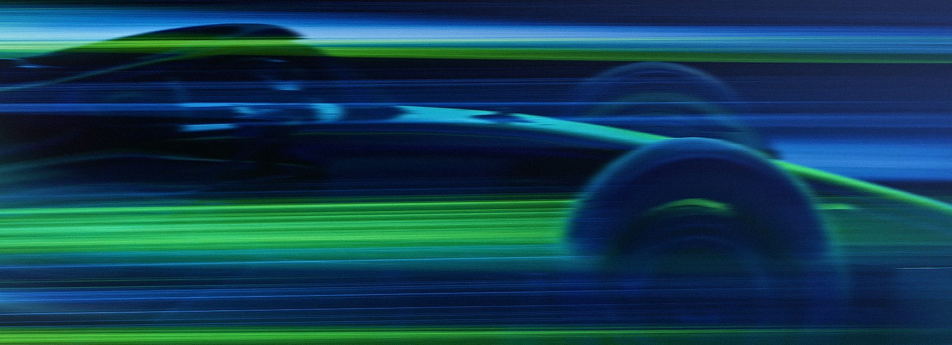 Blue and green light blurs across the screen. From the streaks of colour, the shape of a car emerges.