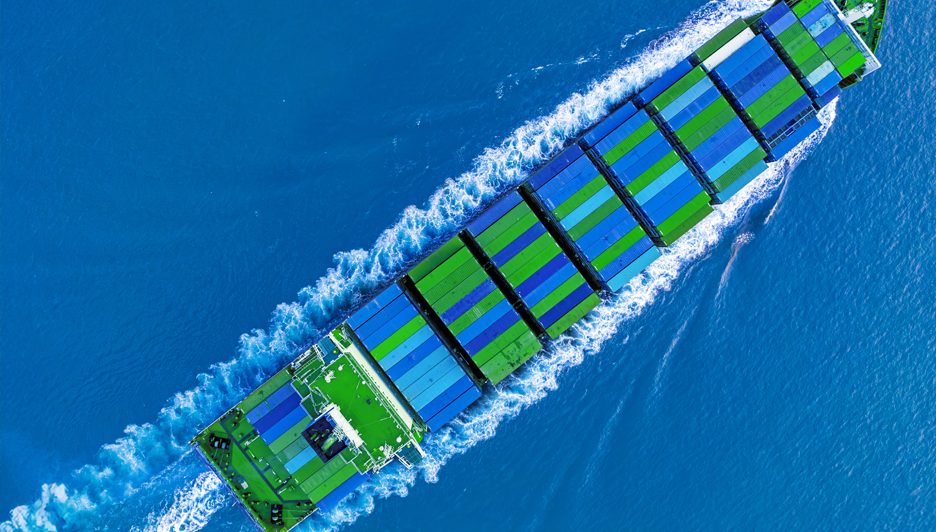 A ship transporting blue and green containers.