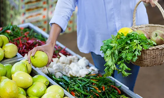 A woman shops for fruit in a supermarket.