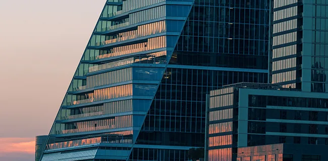 A glass building lit by the setting sun
