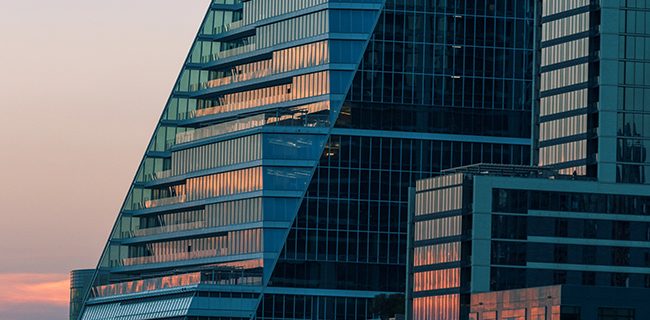 A glass building lit by the setting sun