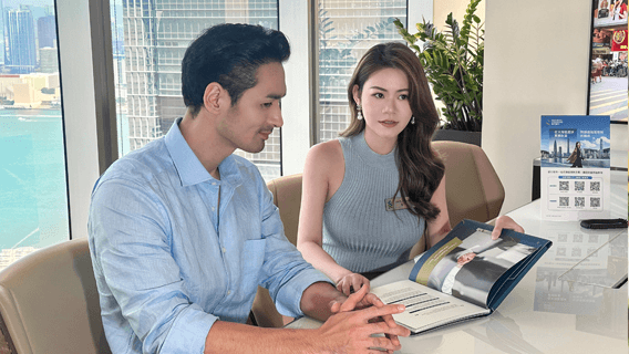 Angela sitting with colleague looking at some work