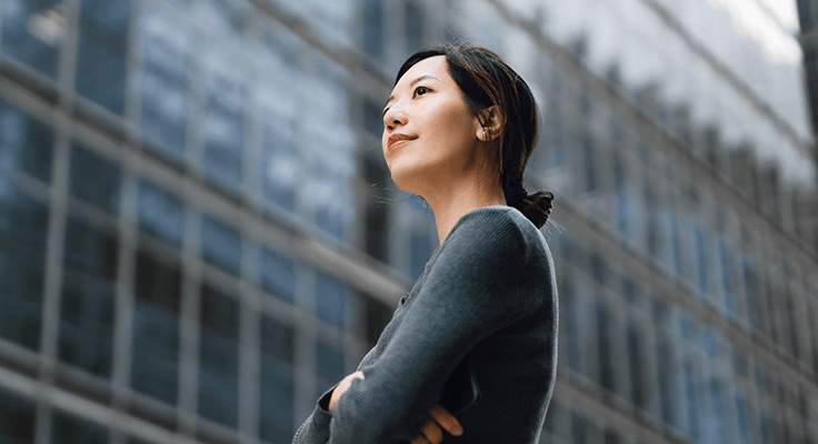A smiling woman in a city.