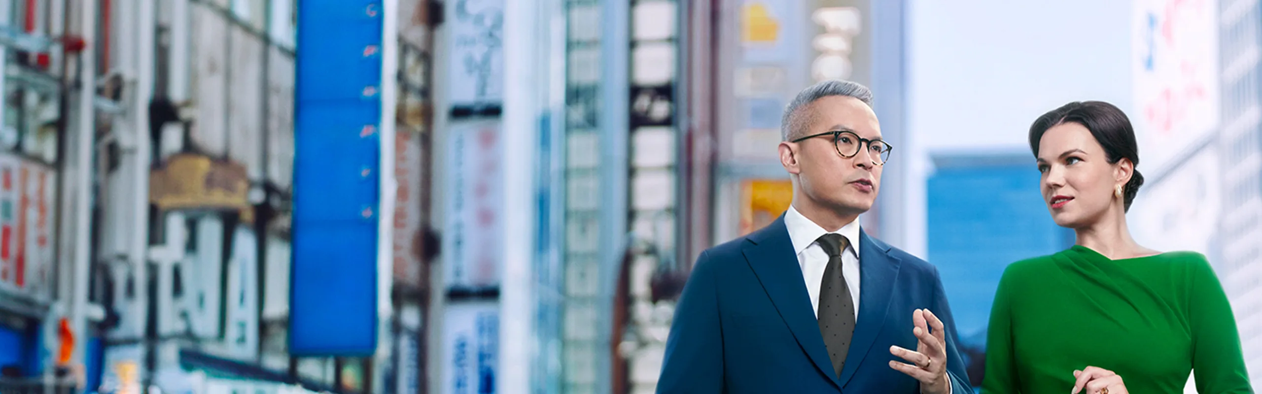 A client strolls the city, talking about investments with their Standard Chartered representative