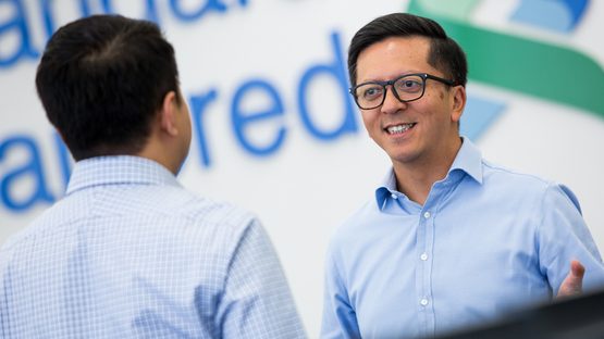 Two men discussing capital and securities at Standard Chartered Bank
