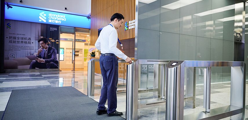 A Standard Chartered employee badges in to an office.