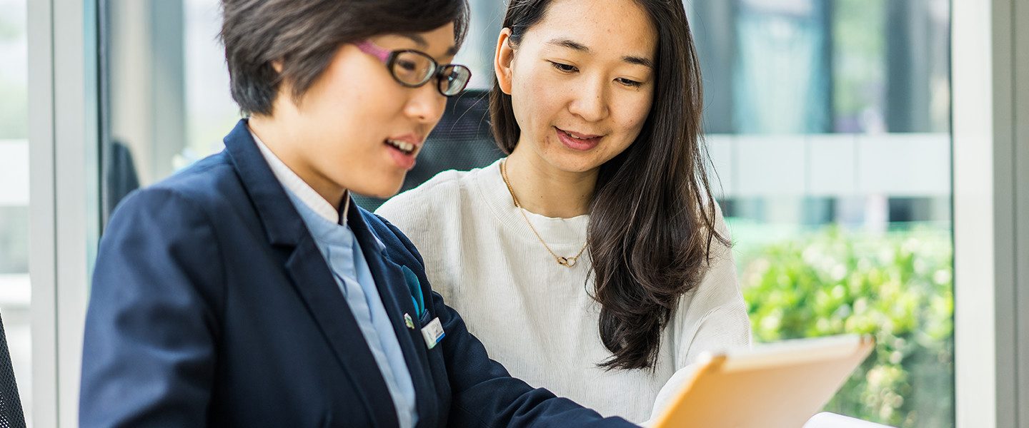 2 people working together on tablet