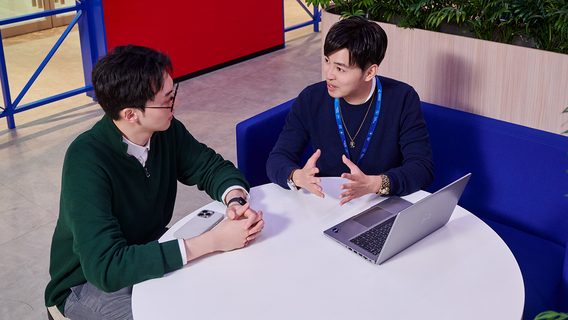 Colleagues discuss skills at a breakout area in a Standard Chartered office.