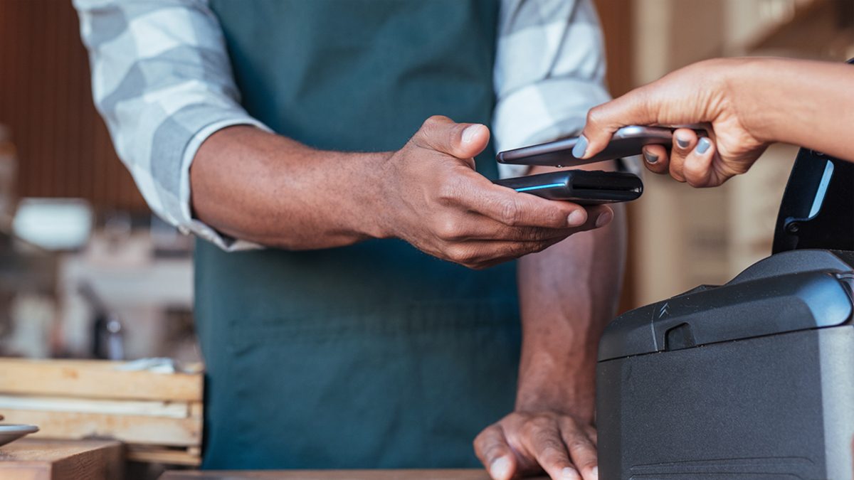 A customer pays with contactless in a cafe.
