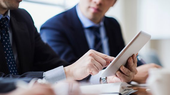 Male boss is in progress a meeting while using a digital tablet