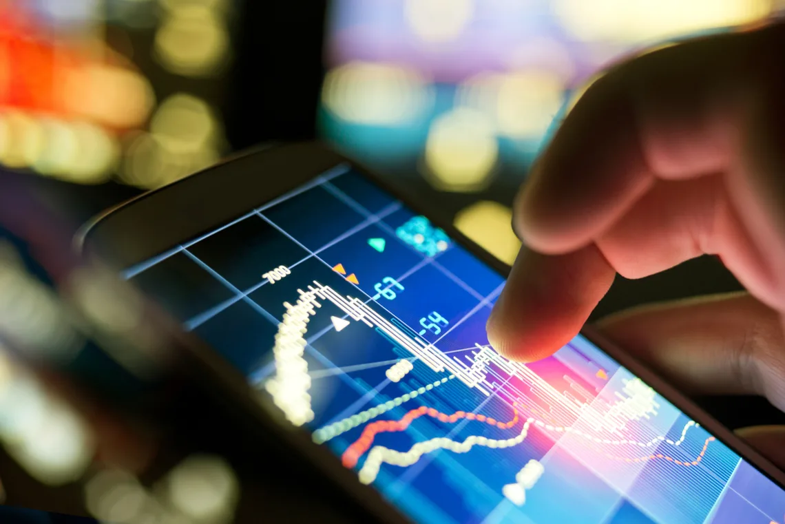 A businessman using a mobile phone to check stock market data, business on the go