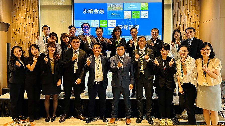 A diverse group of standard chartered colleagues smiling and posing together.