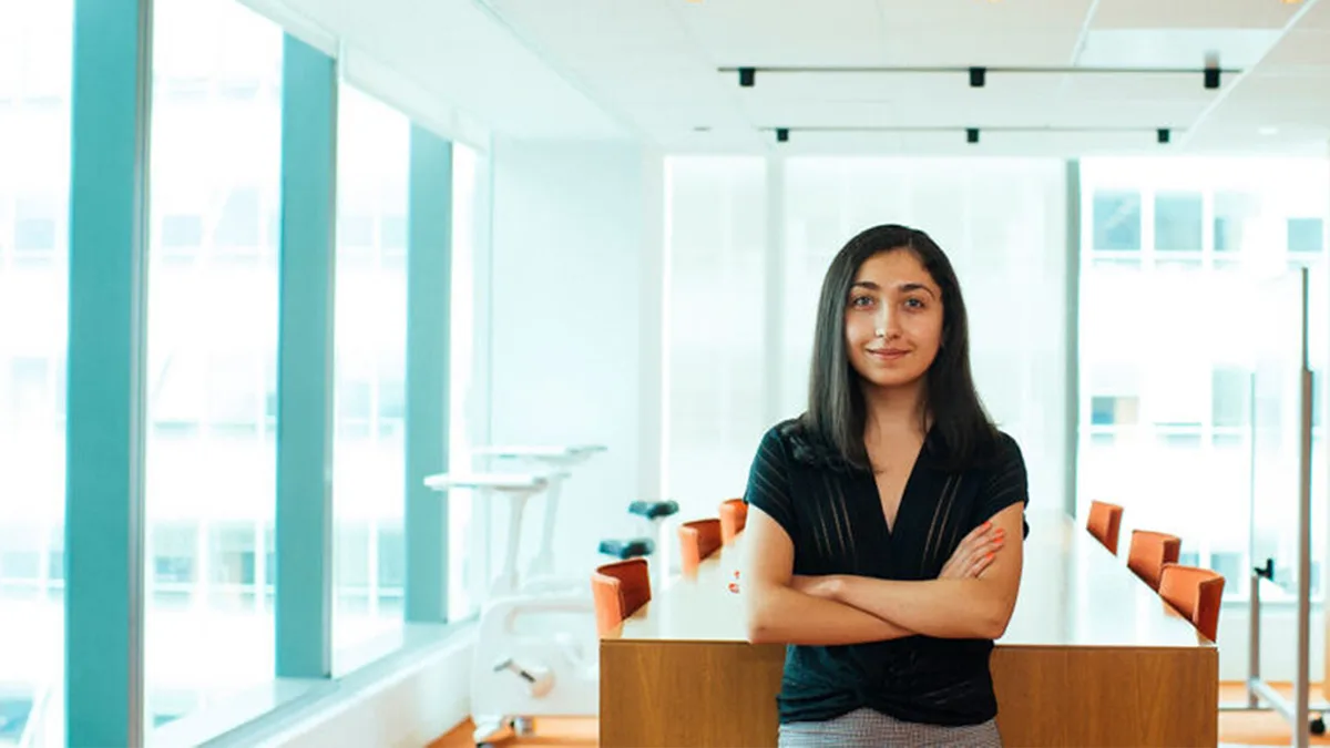 A teenage girl, Elizabeth, poses in a boardroom.