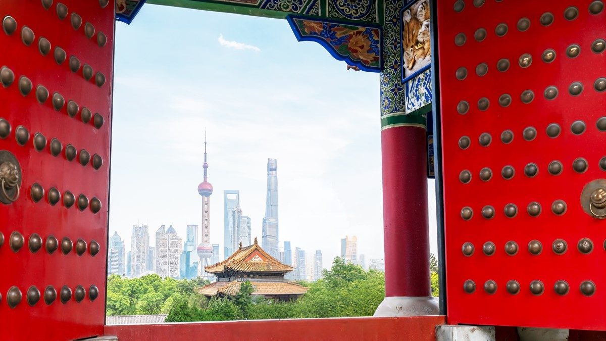 ornate chinese gates framing skyline of shanghai