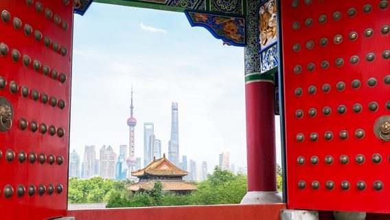ornate chinese gates framing skyline of shanghai