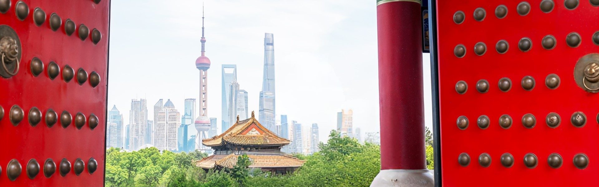 pair of ornate doors framing the skyline of Shanghai