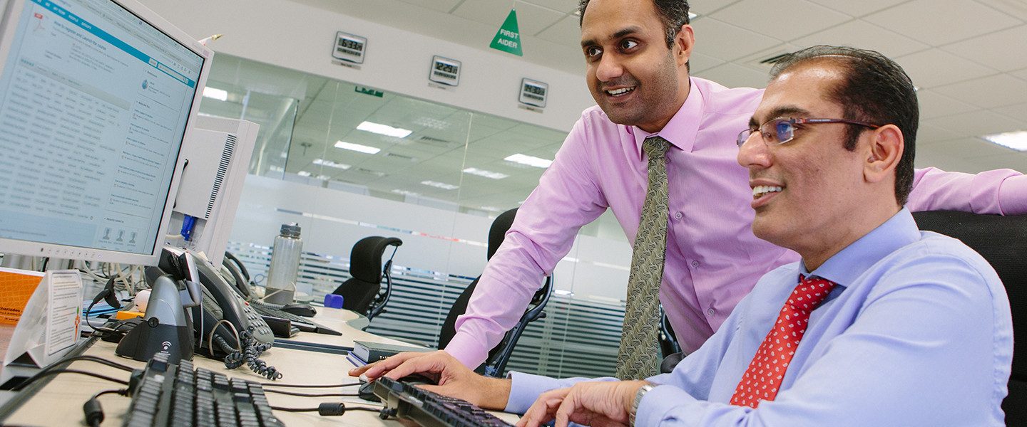 2 people working together at computer