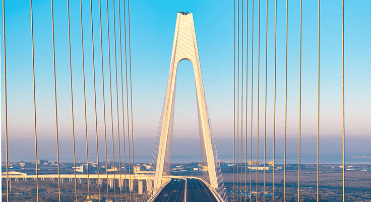 A photograph of a bridge symbolises global shifts in supply chain connectivity.