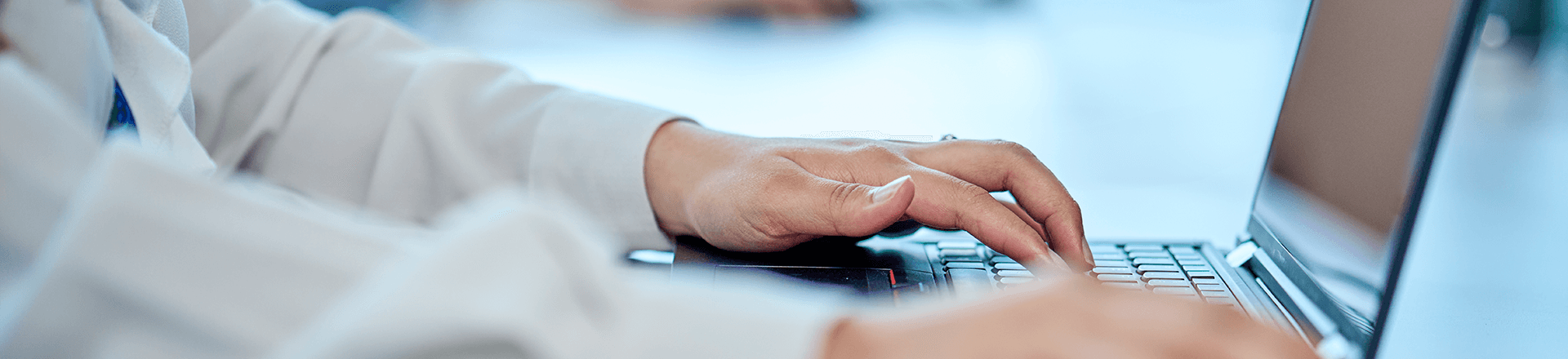 A person focused on typing on a laptop