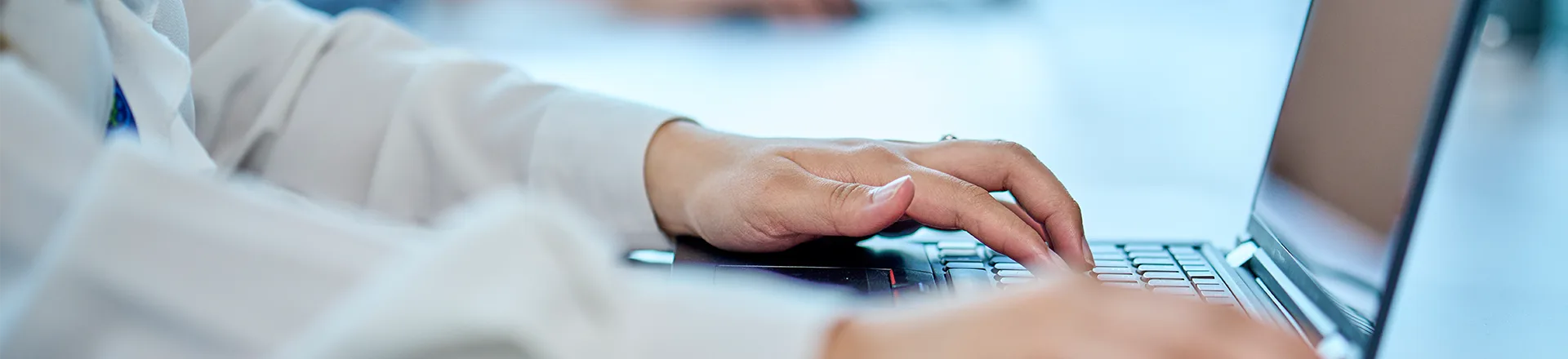 A person focused on typing on a laptop