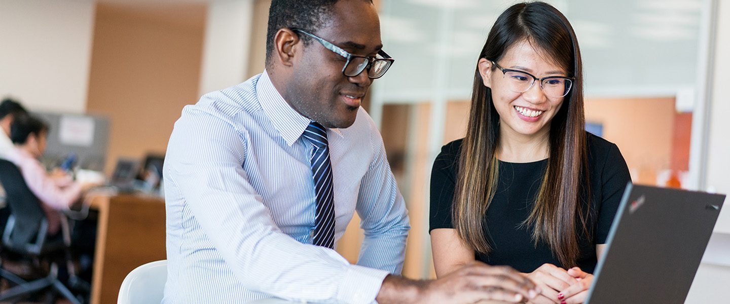 Employees looking at laptop screen