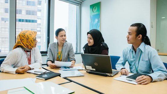 Workers sat around a table having a meeting
