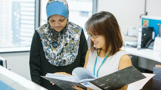 Two employees looking at a file together