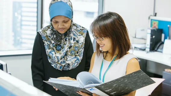 Two employees looking at a file together