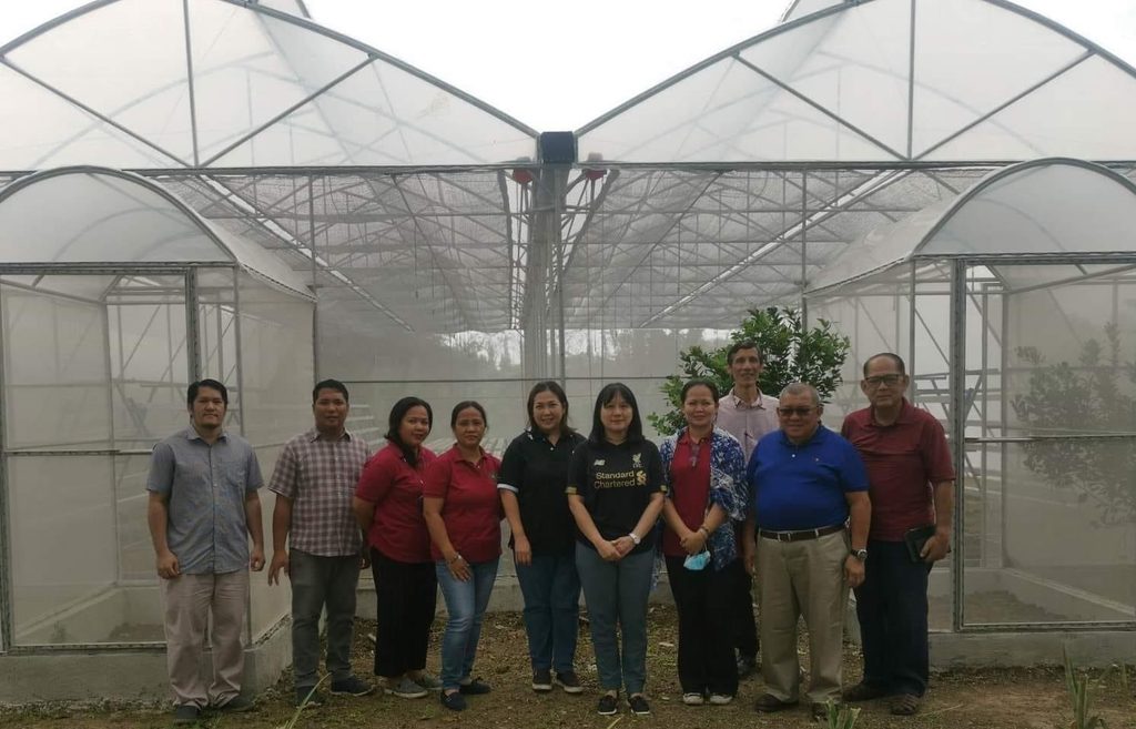 The SC team stand with agriculture school team by the facility