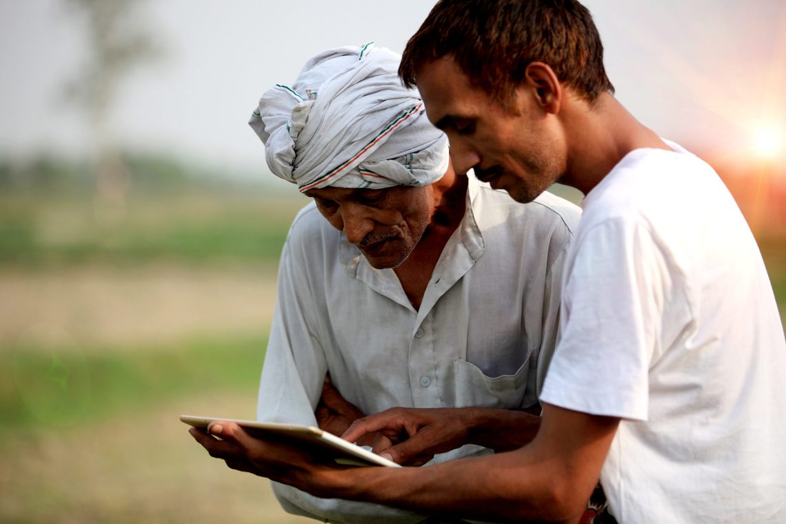 Farmers check their crops and review an Ipad
