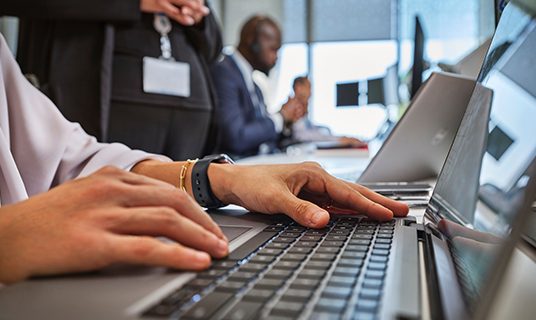 Standard Chartered colleagues work on laptops.