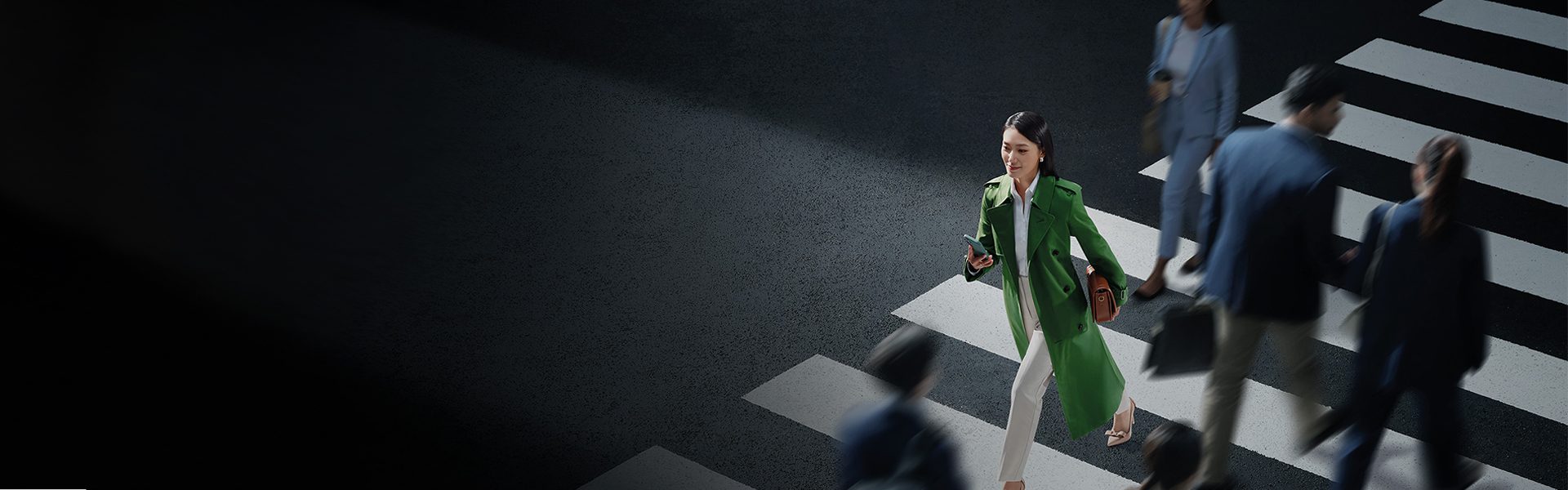 A woman crosses a busy street in a global financial centre.