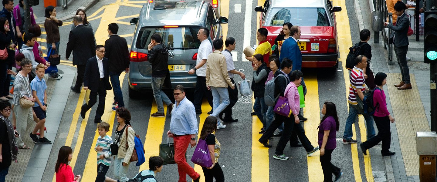 people crossing road in midst of traffic