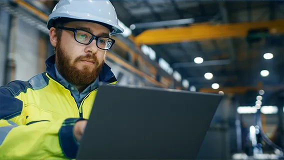 An engineer works on a laptop.