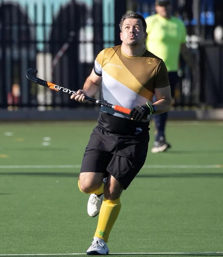 An action shot depicting Peter Cousins competing at the Asian Championships in Hong Kong alongside the Singapore National Masters Hockey Team (over 40s).