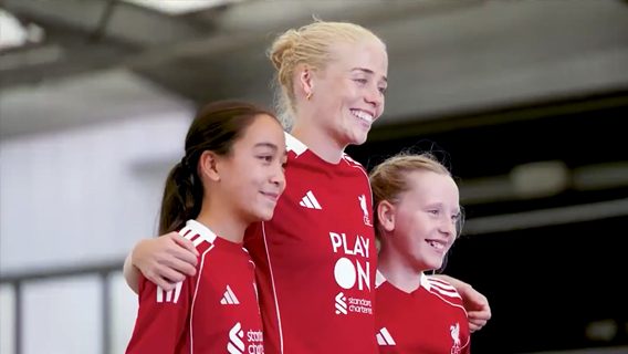 Two young girls smile while meeting an LFC player as part of Play On with Standard Chartered.