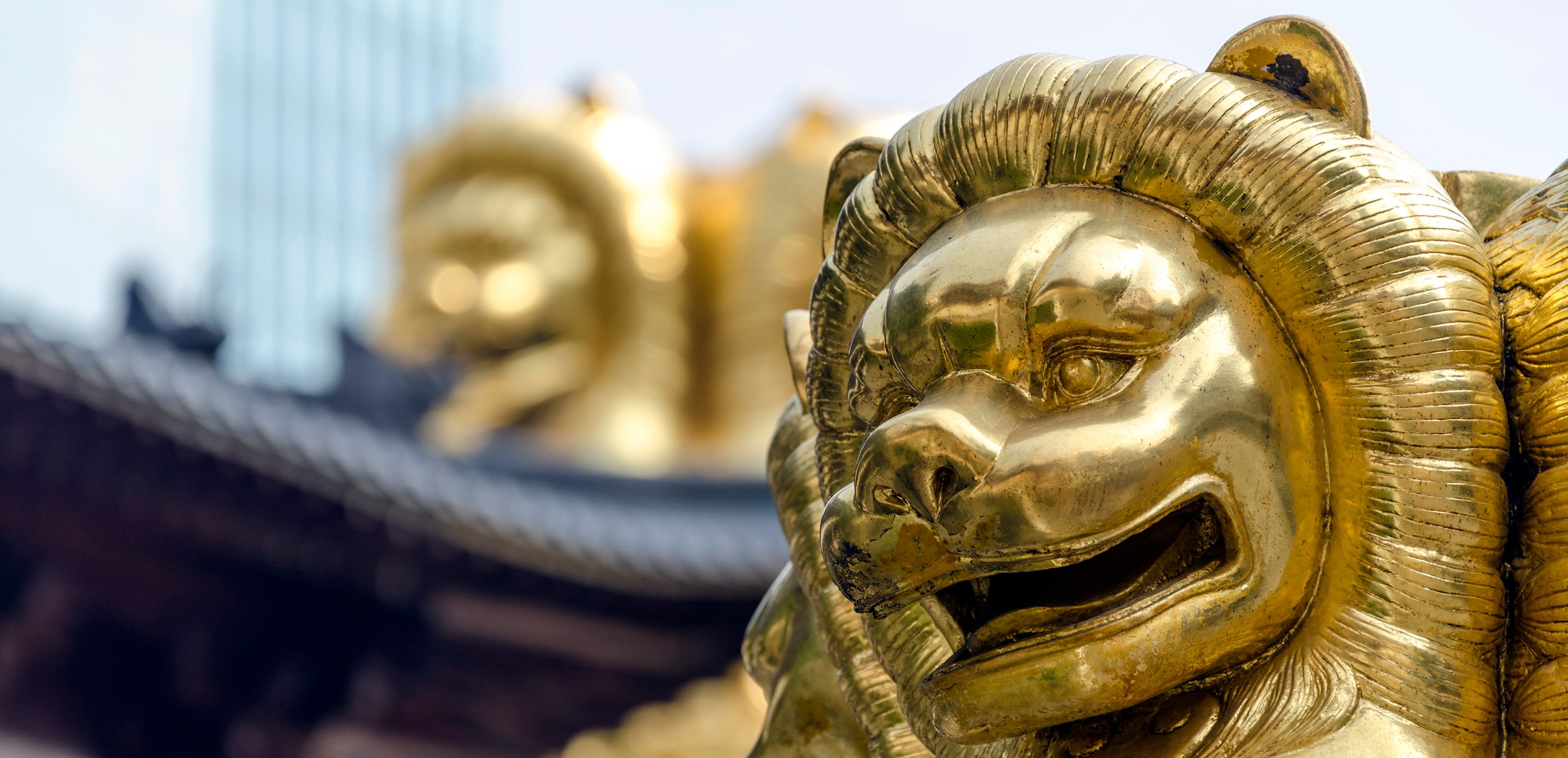 Golden lions against modern skyscrapers in Shanghai.