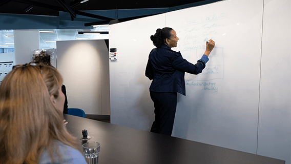 A Standard Chartered employee leads an AI research whiteboarding session.